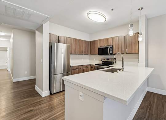 A kitchen with a white countertop and wooden cabinets.