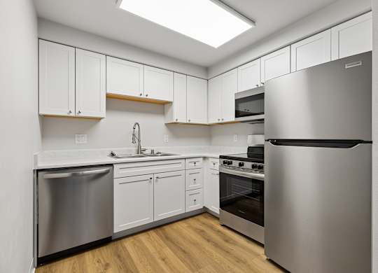 A modern kitchen with stainless steel appliances and white cabinets.