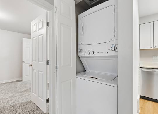 A white oven and microwave are built into a kitchen cabinet.