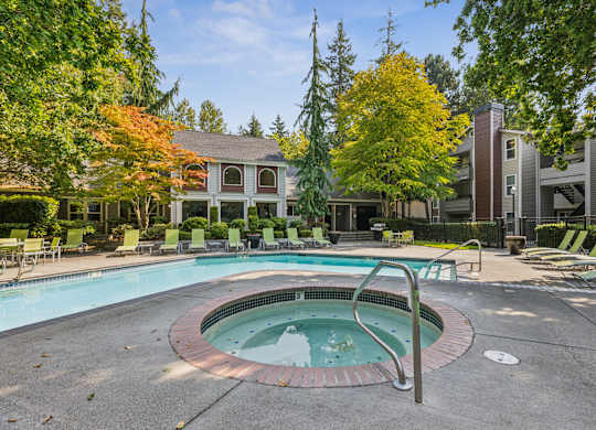 A swimming pool surrounded by trees and chairs.