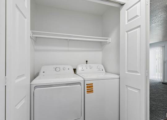 A white laundry room with a washer and dryer.