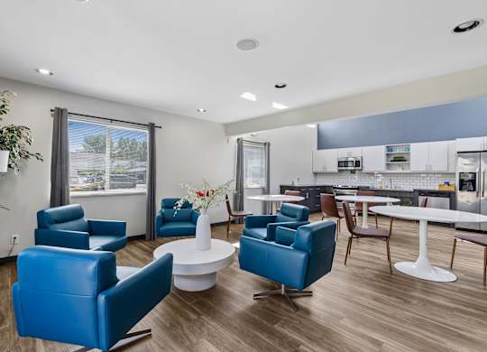 A living room with blue chairs and a white table.