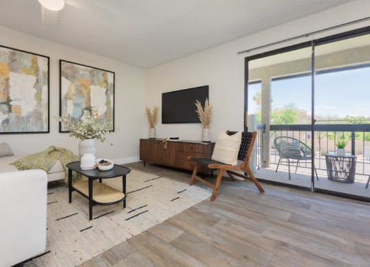 a living room with a couch and a tv and a balcony