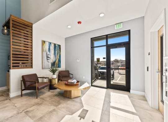 a living room with a table and chairs and a door to a balcony