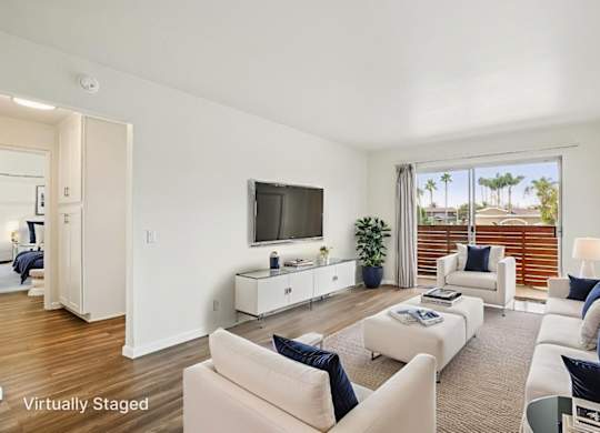 A living room with a white couch and a television.