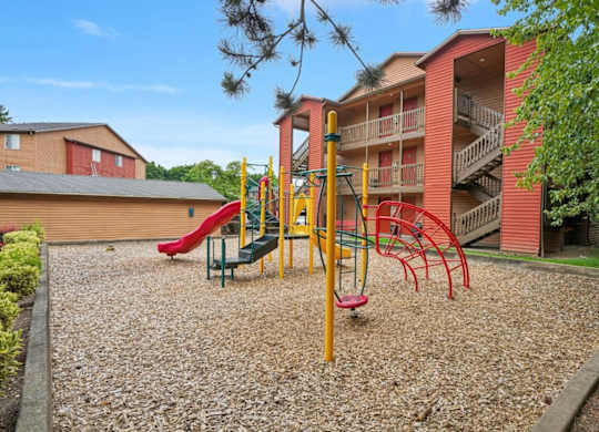 A playground with a red slide and a yellow structure.