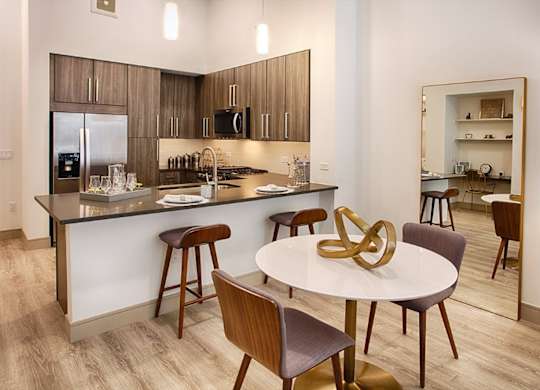 A modern kitchen with a dining table and chairs.