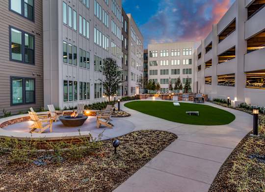 A courtyard with a fire pit surrounded by buildings.