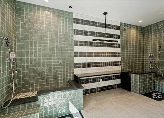 A modern bathroom with a walk-in shower and a bench seat.