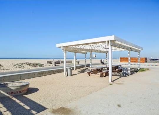 A white beach pavilion with a caution tape on the ground.