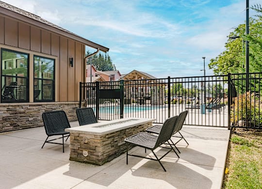 A patio with a table and chairs is in front of a house.