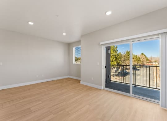 a living room with a sliding glass door to a balcony