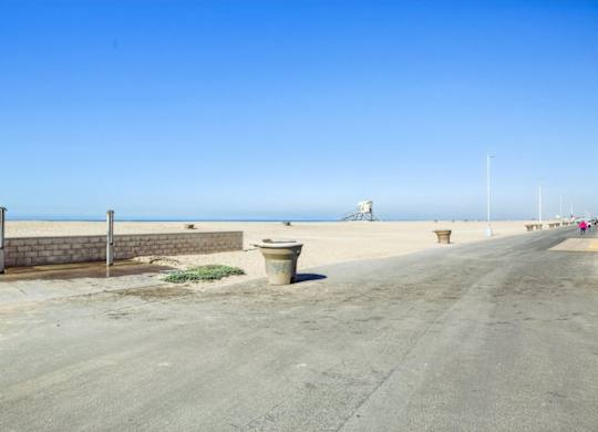 A road with a wall and a trash can in the middle.