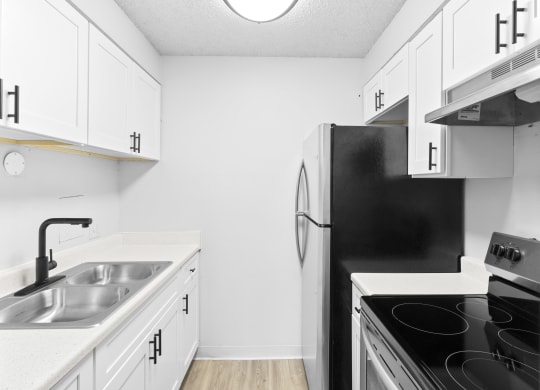 Proximity Apartment Homes Kitchen with stainless steel appliances and white cabinets
