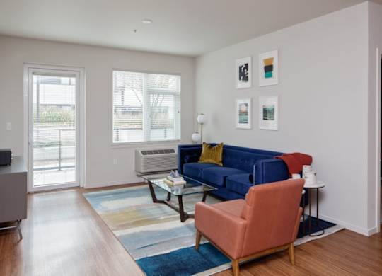 A living room with a blue couch and a red chair.