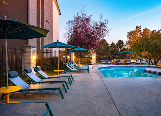 Clover Creek Apartments Pool Area and Lounge Chairs at Dusk