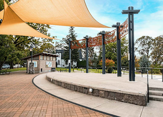 A park with a yellow canopy and a small building.