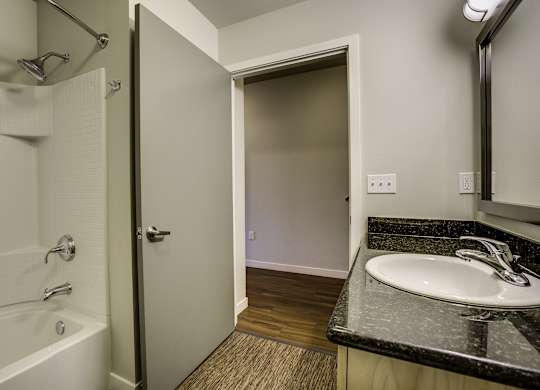 A bathroom with a white tub and sink.