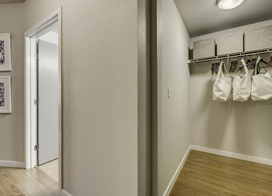A hallway with a white door and a wall with two pictures on it.