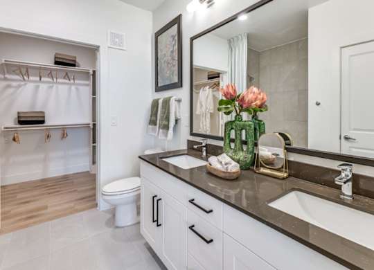 A bathroom with a white toilet, a sink, and a mirror.