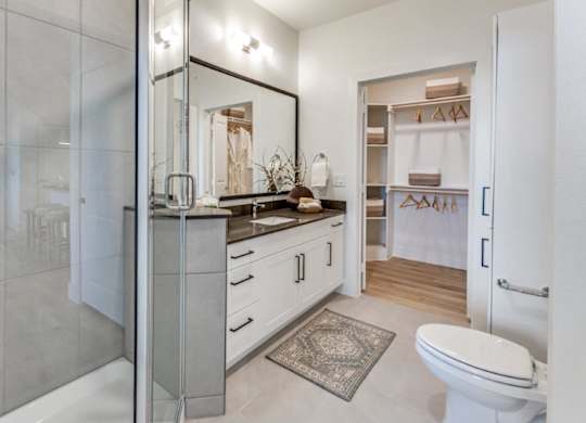 A bathroom with a toilet, sink, and mirror.