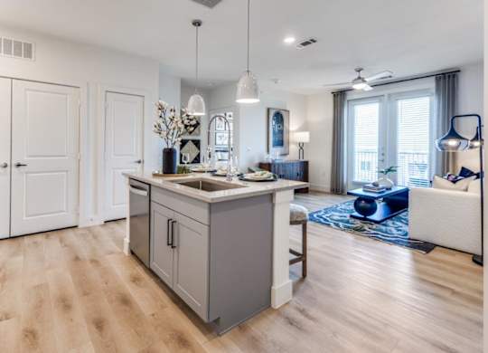 A modern kitchen with wooden floors and white cabinets.