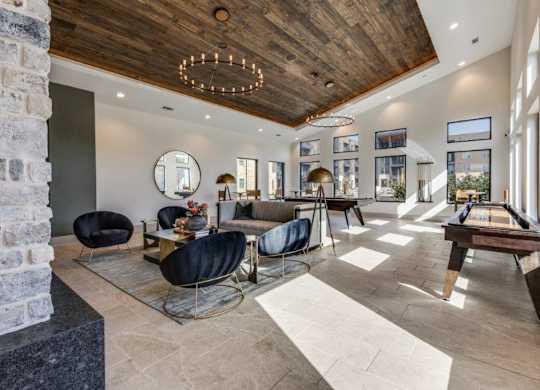 A modern living room with a pool table and a brick wall.