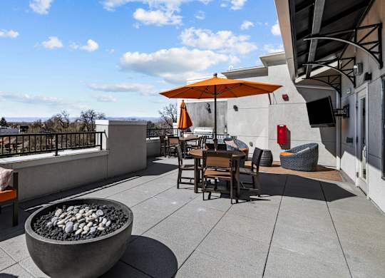 a patio with tables and chairs and a fire pit at Alton Jefferson Park, Denver Colorado