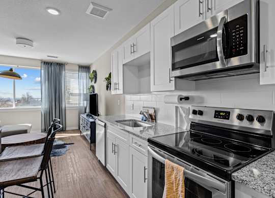 an updated kitchen with white cabinets and stainless steel appliances at Alton Jefferson Park, Denver Colorado