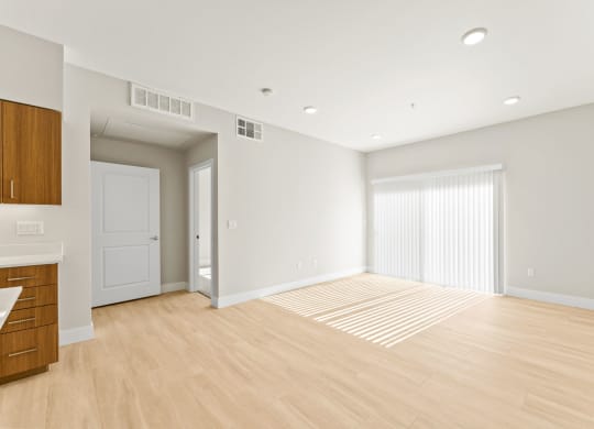 an empty living room with white walls and wood flooring