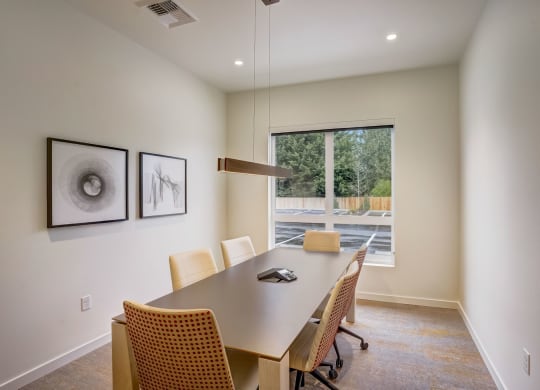 a conference room with a table and chairs and a large window