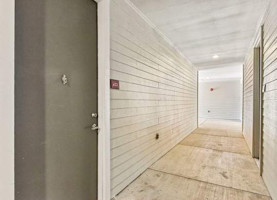 A hallway with a door on the left and a door on the right.
