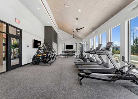 A gym with treadmills, elliptical machines, and other exercise equipment.