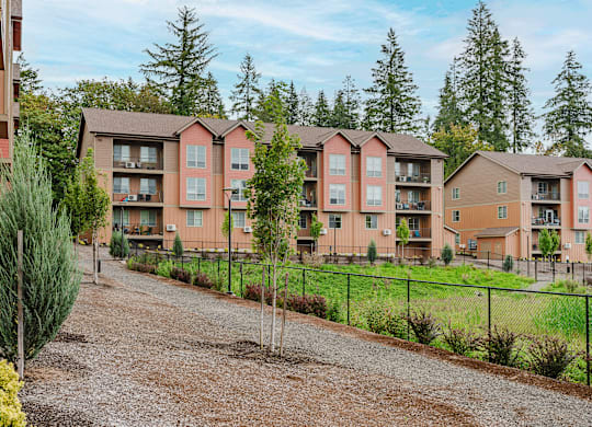 Apartment complex with a gravel driveway in front.