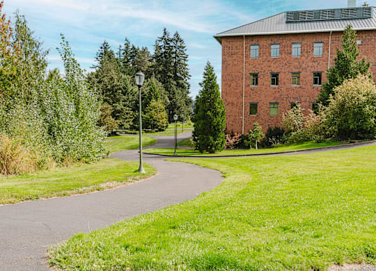 A red brick building with a green lawn in front.