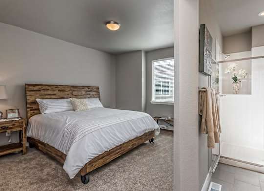 A bedroom with a bed, nightstand, and window.