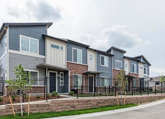 A row of houses with grey and brown exteriors.