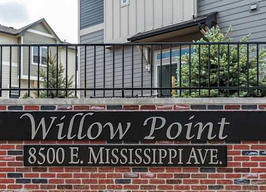 A sign that says Willow Point is on a brick wall.