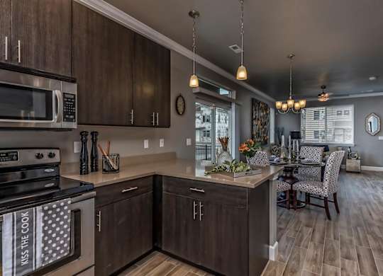 A modern kitchen with dark wood cabinets and a large island.