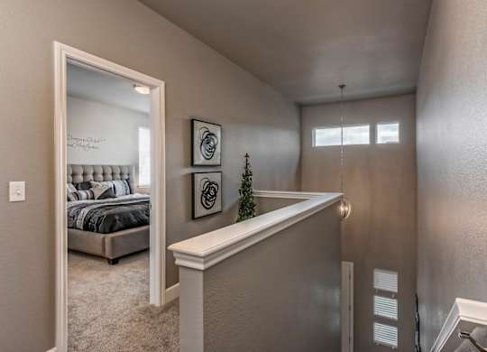 A bedroom with a bed, a mirror, and a small Christmas tree on the counter.