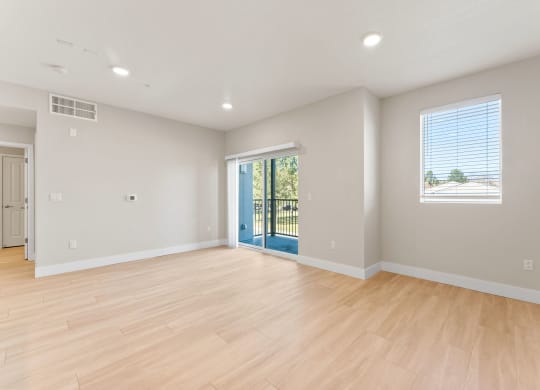 an empty living room with a hard wood floor and a staircase