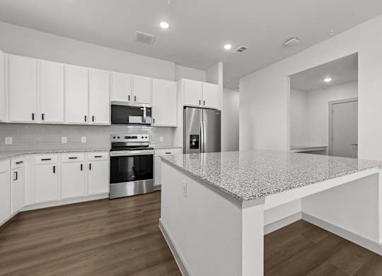 A kitchen with white cabinets and a granite countertop.