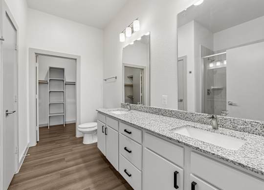 A bathroom with a toilet, sink, and mirror.