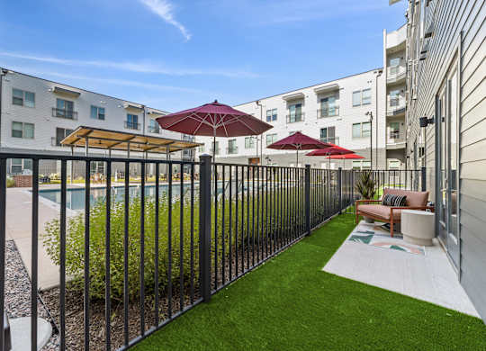 A patio with a pool and a black fence.