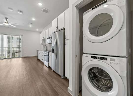 A row of white front loading washing machines in a laundry room.