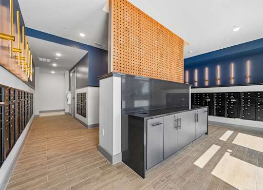 A kitchen with a black counter top and wooden flooring.