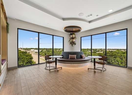 A modern living room with a large window overlooking a green landscape.