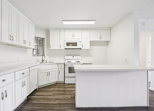 A kitchen with white cabinets and appliances.