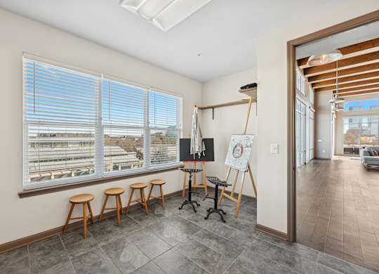 A room with a whiteboard and wooden stools.