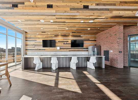 A modern kitchen with a long counter and a wooden ceiling.